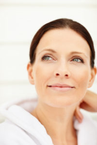 middle aged woman smiling , looking away, refocusing, breathing