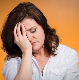 Headshot depressed, gloomy woman on orange background